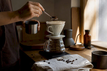 Hands weighing coffee grounds on scale