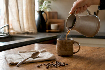 Hand pouring decaf coffee into mug