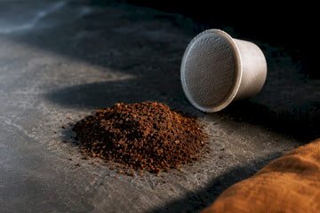 Coffee grounds beside an anonymous coffee pod